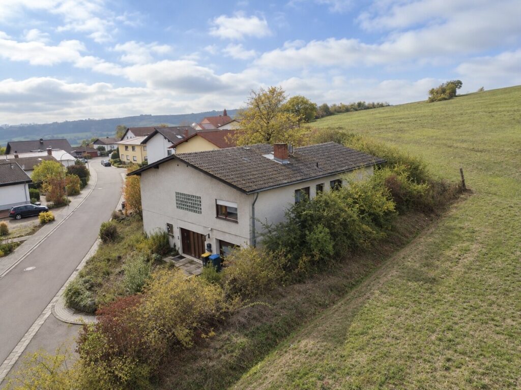 Herbstliches Dorfpanorama mit Haus am Feldrand